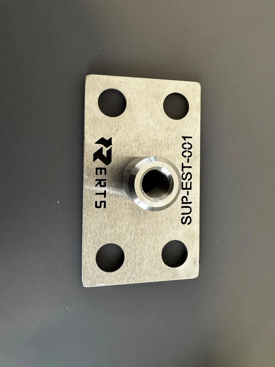 Placa com furos e bucha roscada, com identificação gravada.